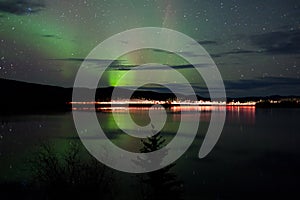 Stars and Northern Lights over dark Road at Lake