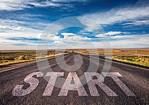 Start concept. Text sign on a long straight road, blue sky background