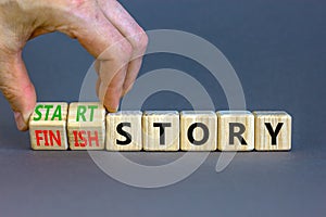 Start or finish story symbol. Concept words Start story and Finish story on wooden cubes. Beautiful grey table grey background.