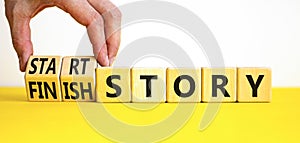 Start or finish story symbol. Concept words Start story and Finish story on wooden cubes. Beautiful yellow table white background