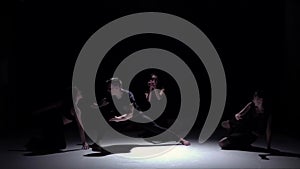 Start graceful contemporary dance of four dancers on black, shadow, slow motion