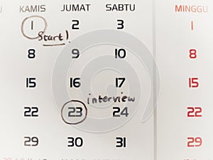 start and interview words written on calendar - 1st and 23rd