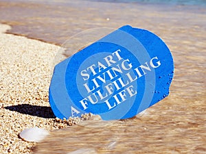 Start living a fulfilling life written on a plank photo