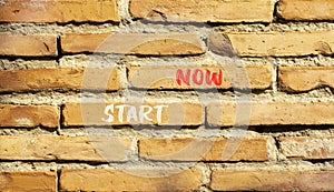 Start now symbol. Concept words Start now on beautiful brown bricks. Beautiful brick wall background. Beautiful brick wall.