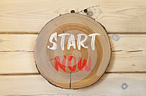 Start now symbol. Concept words Start now on beautiful wooden circle. Beautiful wooden wall background. Business marketing,