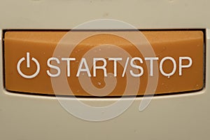 Start and Stop orange button close up
