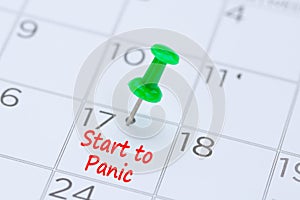 Start to panic written on a calendar with a green push pin to r