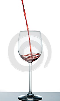 Start to pour red wine into wine glass
