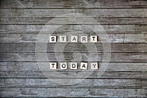 Start today sign is written on a grey wooden table. Motivate business or educational concept. Horizontal