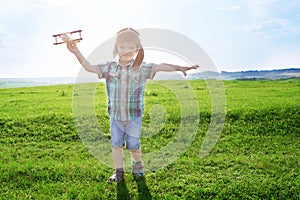 Start traveling from childhood even in imagination. Young Boy playing to be airplane pilot, funny guy with aviator cap