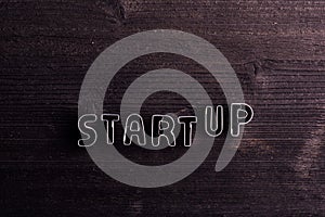 Start up sign made of cookie cutters. Wooden background.