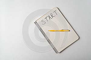 Start written on notebook over white background. Planning new business. Top view