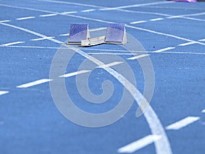 Starting blocks on blue running tracks lanes at track and field stadium. Sport accessory