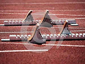 Starting blocks on light red running tracks lanes at track and field stadium