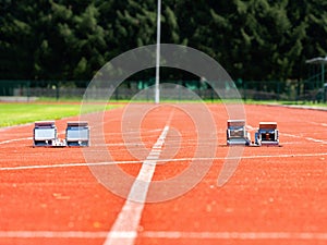 Starting blocks on light red running tracks lanes at track and field stadium