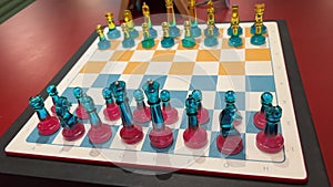 starting a game of chess chess game glass chess of different colors yellow and blue red blue on the board everything is