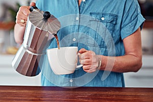 Starting her morning with a little bit of caffeine. an unrecognizable senior woman pouring herself a cup of coffee while