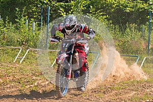 Starting line in motocross competitions. Thick dust rises behind the wheels.