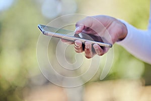 Starting my business journey. an unrecognizable woman using her cellphone while standing outdoors.