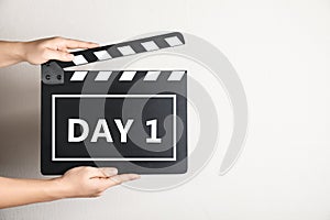 Starting new life chapter. Woman holding clapperboard with text Day 1