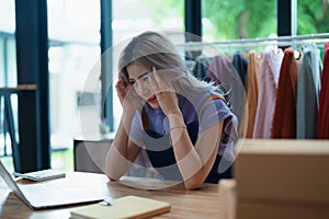 Starting small business entrepreneur of independent Asian woman showing her face worried about the sales of her business