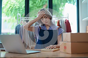Starting small business entrepreneur of independent Asian woman showing her face worried about the sales of her business