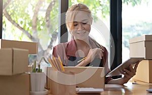 Starting Small business entrepreneur SME freelance,Portrait young woman working at home office, BOX,smartphone,laptop