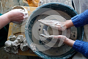 Starting work on a potter`s wheel. top view of the hands of a potter during work