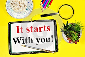 It starts with you. Text caption in notepad for inspiration.