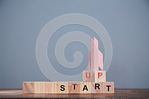 Startup and aspirations. New business, development and investment concept. Wooden cubes for labels and rocket.