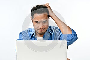 Startup business man holding his head looking stressed while working on a laptop