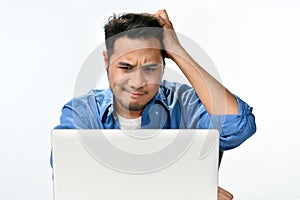 Startup business man holding his head looking stressed while working on a laptop