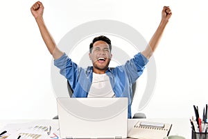 Startup business man raising his hands feeling happy for achieving work while using laptop