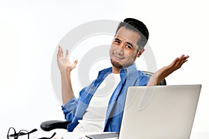 Startup business man sitting in relaxed posture with hands raised after having work done easily