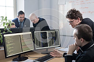 Startup business problem solving. Software developers working on desktop computer. photo