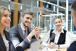 Startup business team on meeting in modern bright office interior and working on laptop