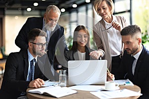 Startup business team on meeting in modern bright office interior and working on laptop