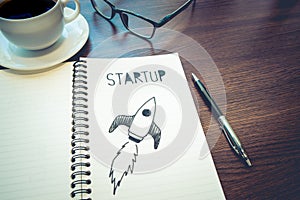 Startup concepts idea.rocket drawing on notepad.business investment