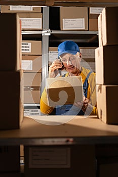 Startup small business concept. Elderly man working in warehouse, distribution center, post office