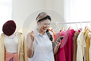 Startup SME small business entrepreneur of freelance Asian woman using smartphone Cheerful success Asian woman her hand lifts up