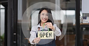 Startup successful small business owner sme beauty girl stand hand hold open sign coffee shop or restaurant. Portrait of