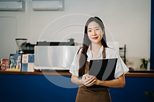 Startup successful small business owner sme woman stand with tablet in cafe. woman barista cafe owner