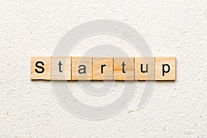 startup word written on wood block. startup text on table, concept