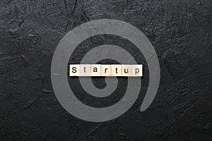 startup word written on wood block. startup text on table, concept