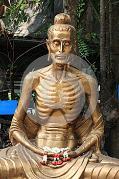 Starving Buddha statue with garland