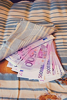 Stash of euros cash in ancient furniture at home. Money is hidden in an old sofa paneling