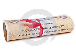 State certificate of the Russian Federation maternal family capital, rolled up in a scroll with a red ribbon.