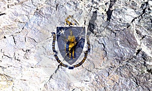 State flag of American state of Massachusetts with blue coat of arms and yellow saber at the top on a white background on mountain