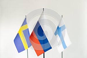 State flag of Russia in focus and Sweden Finland on white background. Conflict, partnership concept