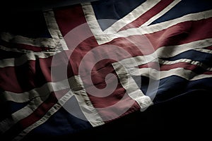 State flag of the United Kingdom of Great Britain Union Jack made of fabric fluttering on a dark background